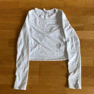 Vit croppad långärmad tröja från H&M Divided - Säljer en enkel och stilren vit långärmad tröja från H&M Divided. Modellen är croppad med rund halsringning och tillverkad i mjuk bomull. Perfekt till jeans eller kjol för en clean look.