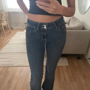 Lågmidjade bootcut jeans med broderade bakfickor - Säljer ett par blå lågmidjade bootcut jeans med vita broderade detaljer på bakfickorna. Från nelly🌸