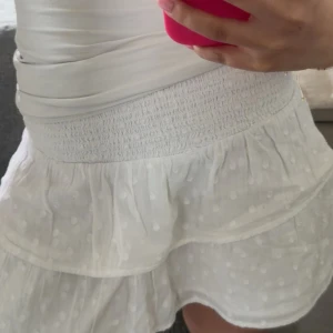 Vit prickig volangkjol - Supersöt vit kjol med volangdetaljer. 