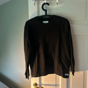 Svart långärmad tröja från Zara - Säljer en svart långärmad tröja från Zara i storlek 164 (13-14 år). Tröjan har en enkel och stilren design med rund halsringning och är tillverkad i ett mjukt material. Perfekt för en avslappnad och snygg look.
