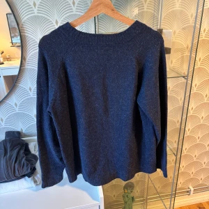 Mörkblå stickad tröja - En enkel och stilren mörkblå stickad tröja med rund halsringning, tröjan har långa ärmar.