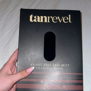 Tanrevel Velvet Self Tan Mitt - En svart, sammetslen self tan-mitt från Tanrevel. Perfekt för att applicera brun utan sol jämnt över kroppen. Handsken är mjuk och har en praktisk ögla för upphängning. Materialet är 100% sammet för en smidig applicering. Oanvänd