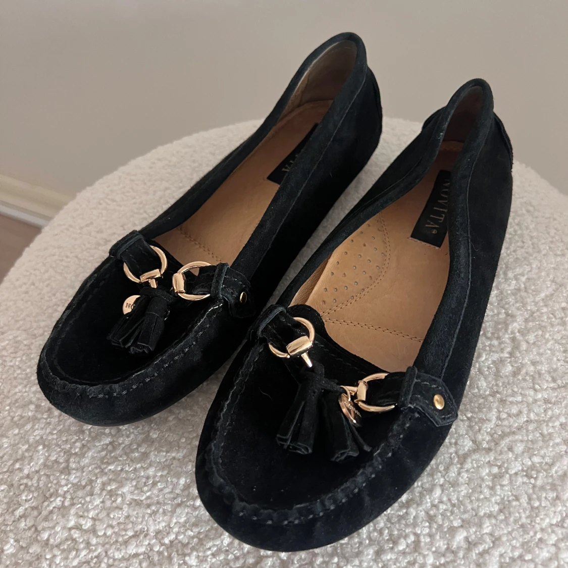 Svarta loafers med gulddetaljer och tofsar