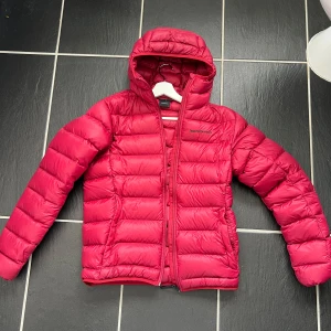 Röd dunjacka från Peak Performance - Säljer en ny röd dunjacka från Peak Performance. Perfekt för kyliga dagar. Klassisk logga på bröstet och ärmen. Snygg och lätt att bära. Nypris 3500kr storlek M