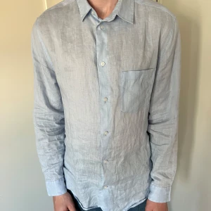 Ljusblå linneskjorta - Säljer denna ljusblå linneskjorta från HMs kvalitativa kollektion ”Essentials”. Skjortan är i bra skick och säljer då den inte passade mig i smaken. Storleken är M men den sitter lite stort så skulle säga att den mer passar L. Beror på vilken stil man kör. Vid minsta funderingar är det bara att höra av sig!