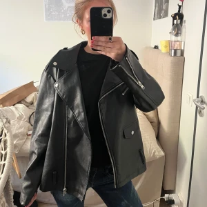 Skitsnygg skinnjacka  - Säljer en svart skinnjacka från NA-KD i storlek 38. Säljer den då jag ej andvänder den! Har haft på mig fåtal gånger och är som ny! Jackan har klassisk bikerstil med silvriga dragkedjor, bred krage och fickor framtill. Perfekt för en edgy look och passar till många outfits.