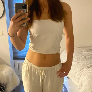 Vit croppad tubtopp  - Säljer en enkel och stilren vit croppad tubtopp från Polarn O. Pyret. Toppen är ärmlös och har en rak passform, perfekt för varma dagar. Mjuk bomullskänsla och minimalistisk design.