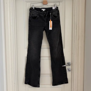 Grå flare jeans - Säljer ett par gråa flare jeans med fickor både fram och bak från Gina young. Byxorna är helt nya med prislapp kvar. 