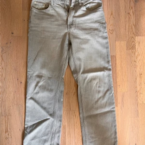 Grå jeans från Weekday - Säljer ett par raka grå jeans från Weekday. Klassisk femficksmodell med dragkedja och knapp framtill. Tidlös design och neutral färg som passar till mycket. Perfekt för dig som gillar enkel och stilren look.