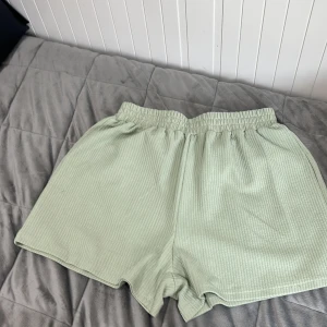 Ljusgröna ribbade shorts från SHEIN - Superbekväma ljusgröna shorts från SHEIN med ribbad struktur och elastisk midja. Perfekta för varma dagar eller som mysplagg hemma. Lätta och luftiga med avslappnad passform.