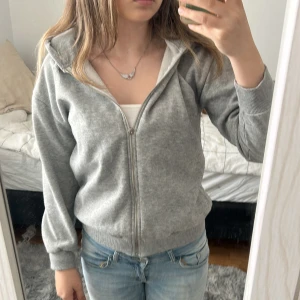 Grå ziphoodie med stjärndetaljer - Grå hoodie med dragkedja och huva. Mjukt material och ribbade muddar. Stjärnapplikationer i vitt på ryggen och ena ärmen ger en unik touch. Perfekt för en avslappnad stil. Från Gina tricot 💘