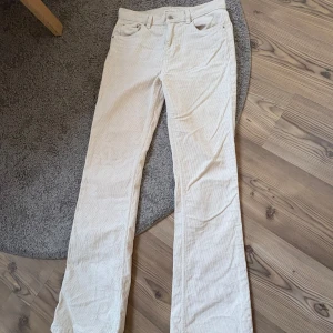Vita manchesterbyxor  - Säljer ett par vita manchesterbyxor från Gina Tricot med klassisk femficksdesign och raka ben. Byxorna är mid waist och är tillverkade i mjuk manchester, perfekta för en stilren look.