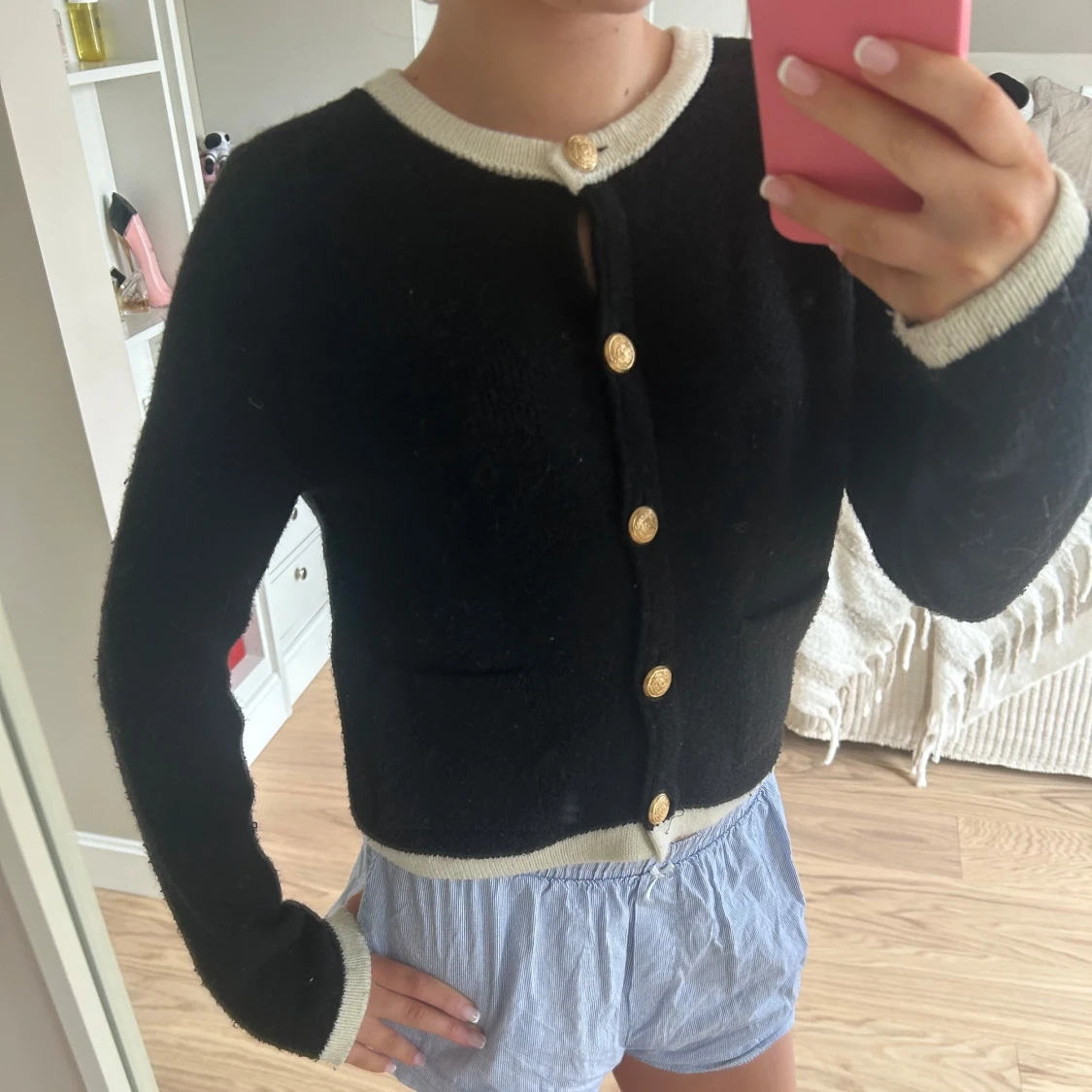 Svart kofta med guldfärgade knappar