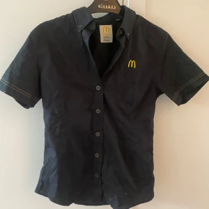Svart kortärmad skjorta från McDonald's - McDonald’s jobbtröja. Använt en gång. Passar XS-S