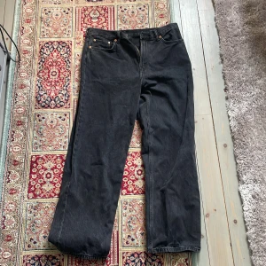 Svarta straight jeans från Weekday - Säljer ett par svarta straight fit jeans från Weekday i modellen Galaxy Loose Straight. Klassisk femficksdesign och normal passform med raka ben. Perfekta till vardags och lätta att matcha med olika stilar.