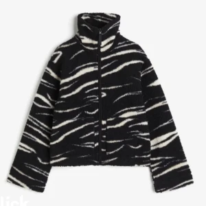 Svart och vit teddyjacka med zebramönster - Säljer en svart teddyjacka med vitt zebramönster och dragkedja framtill. Jackan har hög krage och långa ärmar. Supermjuk och skön att ha på sig.