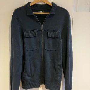 En skön tröja  - Tja, säljer den här snygga tröjan med zip. Tröjan är köpt o Nederländerna för nåt år sen men har inte blivit använd mycket. Den är strl Small men skulle säga att den funkar på någon med strl Medium lika väl. Skick 9/10!  Kom pm vid intresse eller frågor!