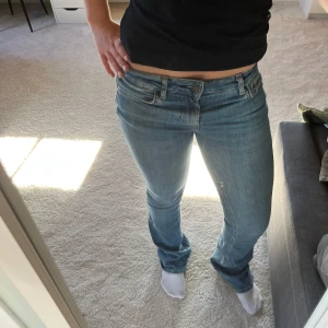Lågmidjade blå jeans med bootcut - Säljer ett par klassiska blå jeans med låg midja och bootcut-ben. Jeansen har fem fickor, dragkedja och knapp framtill. Perfekta för dig som gillar en tidlös och avslappnad stil.