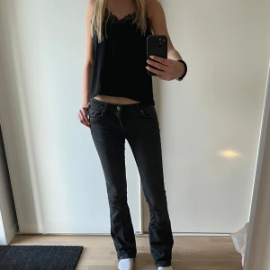 Svarta lowwaist bootcut jeans - Säljer ett par svarta bootcut jeans med låg midja. från zara. Dom är slitna där bak vilket syns på sista bilden, men går säkert att laga 