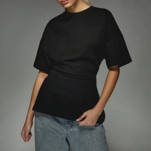 Svart t-shirt från Missguided - En svart t-shirt från Missguided med klassisk passform och rund hals. T-shirten har korta ärmar och är tillverkad i mjuk bomull, perfekt för en enkel och stilren look. Passar till jeans eller shorts. I storlek L helt oanvänd