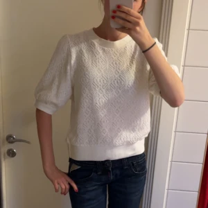Vit spetsmönstrad tröja med puffärm från Lindex - Säljer en söt vit tröja med spetsmönster och rund hals. Tröjan har puffiga trekvartsärmar och bred mudd i midjan. Från märket Holly & Whyte från Lindex. Den har inga defekter! Tröjan är i storlek M men är ganska linte i storleken så passar som S💕
