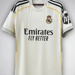 Real Madrid vit matchtröja Adidas - Snygg vit Real Madrid fotbollströja från Adidas med svarta ränder på axlarna, gula detaljer längs sidorna och klubbmärke på bröstet. Tryck med 'Emirates Fly Better' på framsidan och HP-logga på ärmen. Perfekt för dig som älskar fotboll och vill visa ditt stöd. Går att fixa eget nummer och namn dock 85 kr dyrare