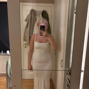 Vit långklänning från Chiquelle - Säljer en stilren vit långklänning från Chiquelle i storlek medium. Klänningen har smala axelband och figurnära passform som framhäver siluetten. Materialet är mjukt och stretchigt, perfekt för dig som gillar minimalistisk och clean look.