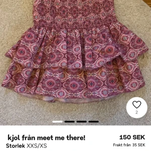 Rosa mönstrad volangkjol Meet Me There - Supersöt kort kjol från Meet Me There i rosa med ett boho-inspirerat mönster. Kjolen har två volanger och en smockad midja som gör den bekväm och lätt att bära. Perfekt för dig som gillar färg! Inbyggde shorts