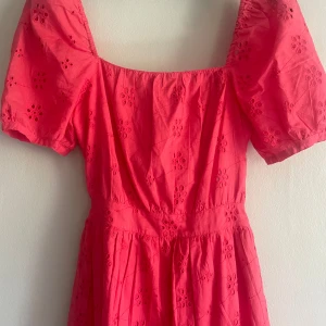 Rosa kort klänning från ONLY - Söt rosa klänning från ONLY i storlek XS med puffiga korta ärmar och broderade blommor samt öppen rygg med knut. 