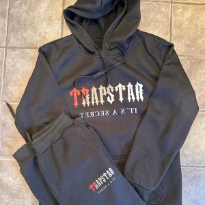 Trapstar byxor - Hej säljer trapstar byxorna på bilden har tappat bort hoddien darför jag bara säljer byxorna men dom är i bra skick, färgen är svart men Röd/grå/vit text, storleken är S/M