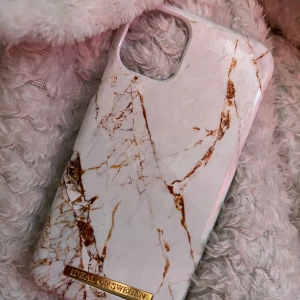 mobilskal iphone 11🤍 - Snyggt mobilskal från iDeal of Sweden till Iphone 11!med vit bas och marmormönster i guld! Skalets design är stilren med en lyxig känsla och har en guldfärgad logga längst ner. Passar perfekt för dig som vill ha en trendig look till mobilen.spricka längst nere på skalet vid guld loggan💕⭐️