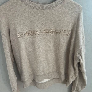 Beige sweatshirt från Carin Wester - Säljer en beige sweatshirt från Carin Wester i storlek XS. Tröjan har broderad logga framtill och är tillverkad i mjuk bomullsmix. Rund hals och ribbade muddar vid ärmslut och nederkant. Perfekt för chill dagar och enkel att matcha.