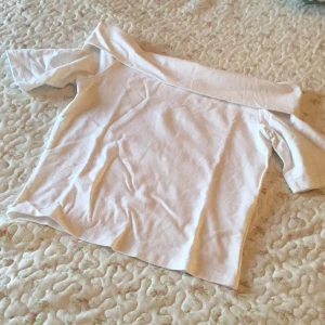 Vit offshoulder topp från LMTD - Säljer en vit offshoulder topp från LMTD i storlek S. Toppen har korta ärmar och en bred krage som sitter snyggt över axlarna. Tillverkad i mjuk bomull, perfekt för en chill och stilren look. Passar dig som gillar enkel och clean stil.