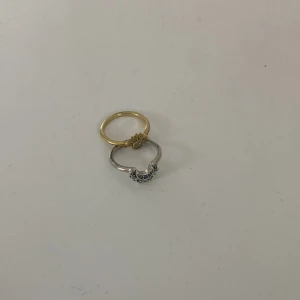 Pandora sun & moon ring - Två snygga ringar, en i guld med solmotiv och en i silver med måne och blå stenar. Perfekt för dig som gillar unika detaljer och vill sticka ut. Båda ringarna har en cool design med små glittriga stenar som ger extra shine. Är från Pandora och är helt nya , kommer med deras boxar oxå , säljer då jag behöver pengar för att köpa annat! 🫶🏽 Jag är 14 år och dem passar men dem passar alla från 11-15 år. ⚠️OBS DET ÄR ENDAST SOL OCH MÅNE RINGEN INTE DEM ANDRA SOM KOMMER PÅ DEN SISTA BILDEN!!!!