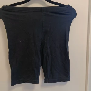 Svarta cykelshorts i bomull - Svarta, enkla cykelshorts med midwaist passform. Mjukt och stretchigt material i bomull som sitter skönt mot kroppen. Perfekta för chill eller träning, med en clean look utan detaljer eller mönster.