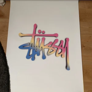 Stussy affisch  - Stil ren vit Stüssy-affisch med den ikoniska loggan – ett måste för alla som gillar streetwear och modern inredning. Perfekt som väggdekoration i sovrummet, vardagsrummet eller i ett kreativt utrymme. Enkel, trendig och full av attityd. Redo att ramas in eller hängas upp som den är!