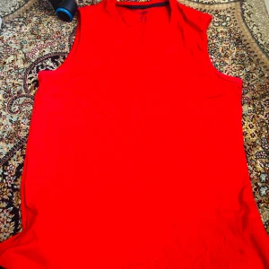 Röd ärmlös linnetopp från Livergy XL - Snygg röd linnetopp från Livergy i storlek XL. Toppen är helt ärmlös med rund halsringning och tillverkad i mjuk bomull. Perfekt för dig som gillar enkel och stilren design med en poppig färg.