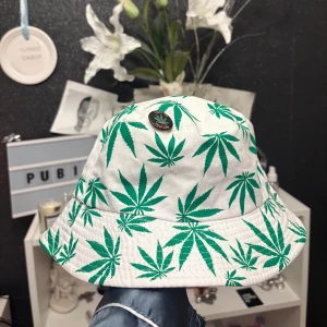 Buckethat gröna blad+broschyr - Säljer denna coola/roliga buckethat med en broschyr som matchar som man kan ta av om man vill. Bra skick.