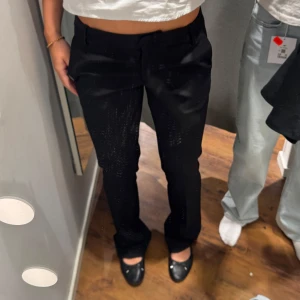 Svarta kostymbyxor - Svarta lågmidjade kostymbyxor från BikBok som tyvärr blivit för små för mig! De är ganska använda men ändå fint skick. Lite slitningar längst nere vid fötterna men annars inga stora skador. Ska även tillägga att de är modellen som har ”extra tall” så de passar längre personer!