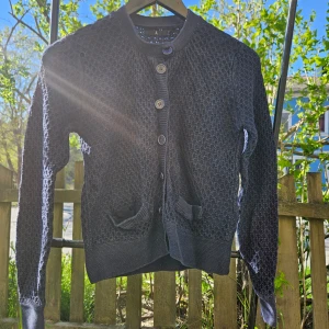 Mörkblå stickad kofta med knappar - Säljer en mörkblå stickad kofta med rund hals och knäppning framtill. 