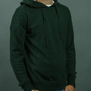 Mörkgrön hoodie - Mörkgrön hoodie med huva och dragsnören. Klassisk modell med lång ärm och ribbade muddar vid ärmslut och nederkant. Perfekt för en avslappnad stil. Det är en storlek L men sitter som en M 