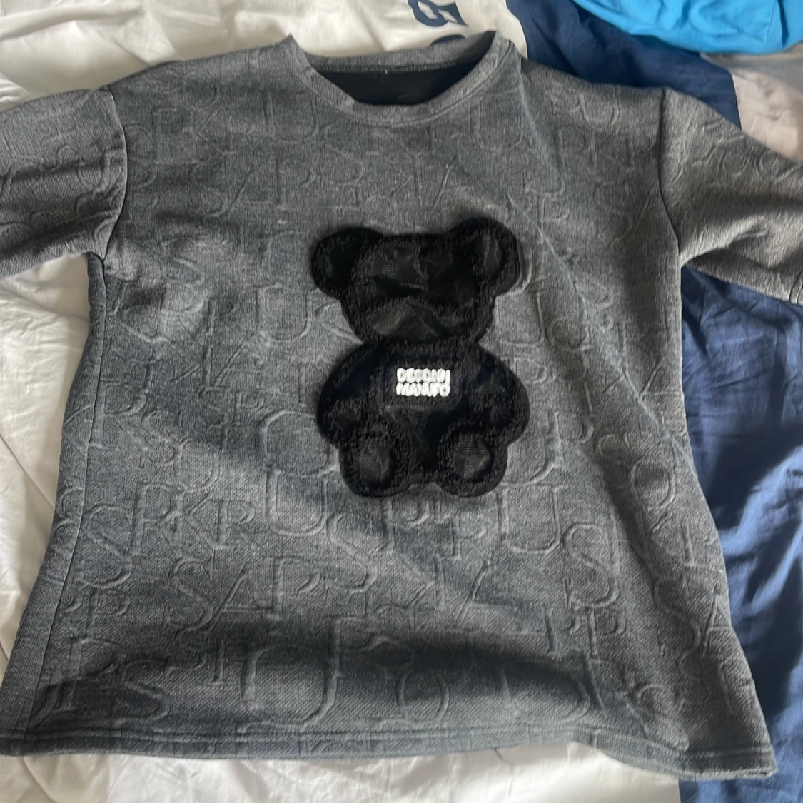 Grå t-shirt med svart nalleapplikation från Design Marufo