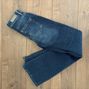 Mörkblå bootcut jeans från ONLY - Säljer ett par klassiska mörkblå jeans från ONLY med bootcut-passform. Jeansen har fem fickor och normalhög midja. Perfekta för dig som gillar en tidlös denimlook.