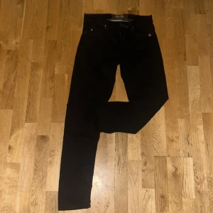 Svarta byxor från Sand - Säljer ett par svarta byxor från Sand i klassisk rak modell. Byxorna har fem fickor, bälteshällor och stängs med dragkedja och knapp. Perfekta till en stilren look och passar till många olika outfits.