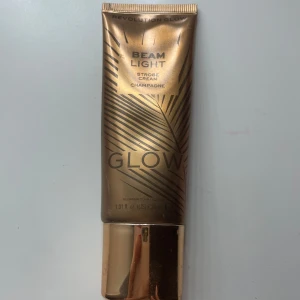 Revolution Glow Beam Light Strobe Cream Champagne - Glow Beam Light Strobe Cream i färgen Champagne från Revolution. Ger en skimrande och lystergivande finish. Kommer i en snygg guldig tub med metallic-detaljer. Perfekt för att framhäva ansiktets höga punkter.