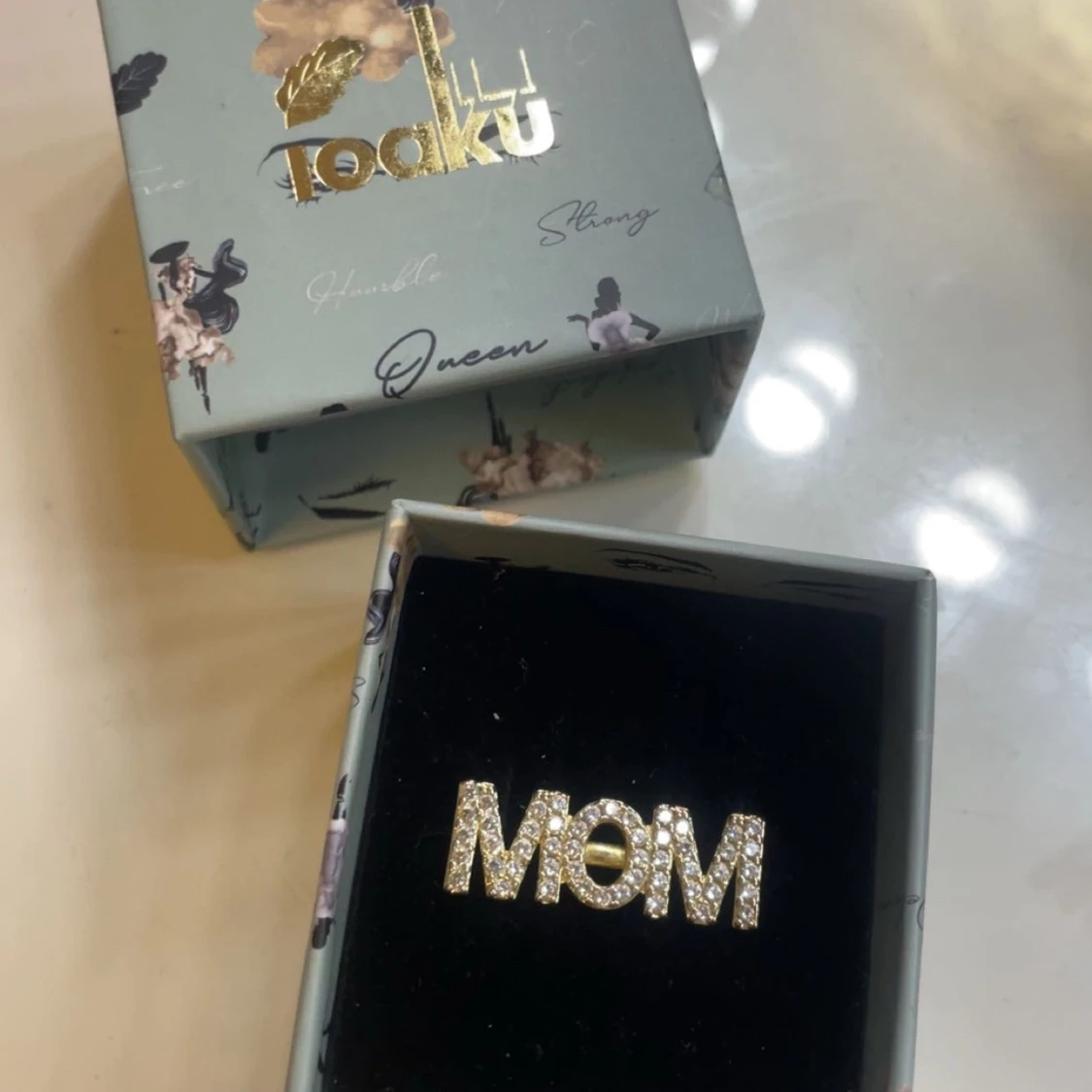 Guldfärgad ring med texten MOM - 1