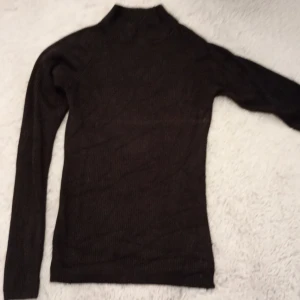 Svart ribbad polotröja från Cubus - Säljer en svart ribbad polotröja från Cubus i storlek XS. Tröjan har lång ärm och är figurnära med hög hals, perfekt för lager-på-lager eller som den är. Enkel och stilren design som passar till mycket.