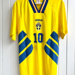 Martin Dahlin - Sverige VM 1994 - Säljer Martin Dahlins klassiska svenska hemmamatchtröja från VM 94 i USA. Tröjan är en remake i nyskick med broderade emblem mm av högsta kvalité.   Large, normal i storleken.  Skickas inom 24 h.  #fotboll 