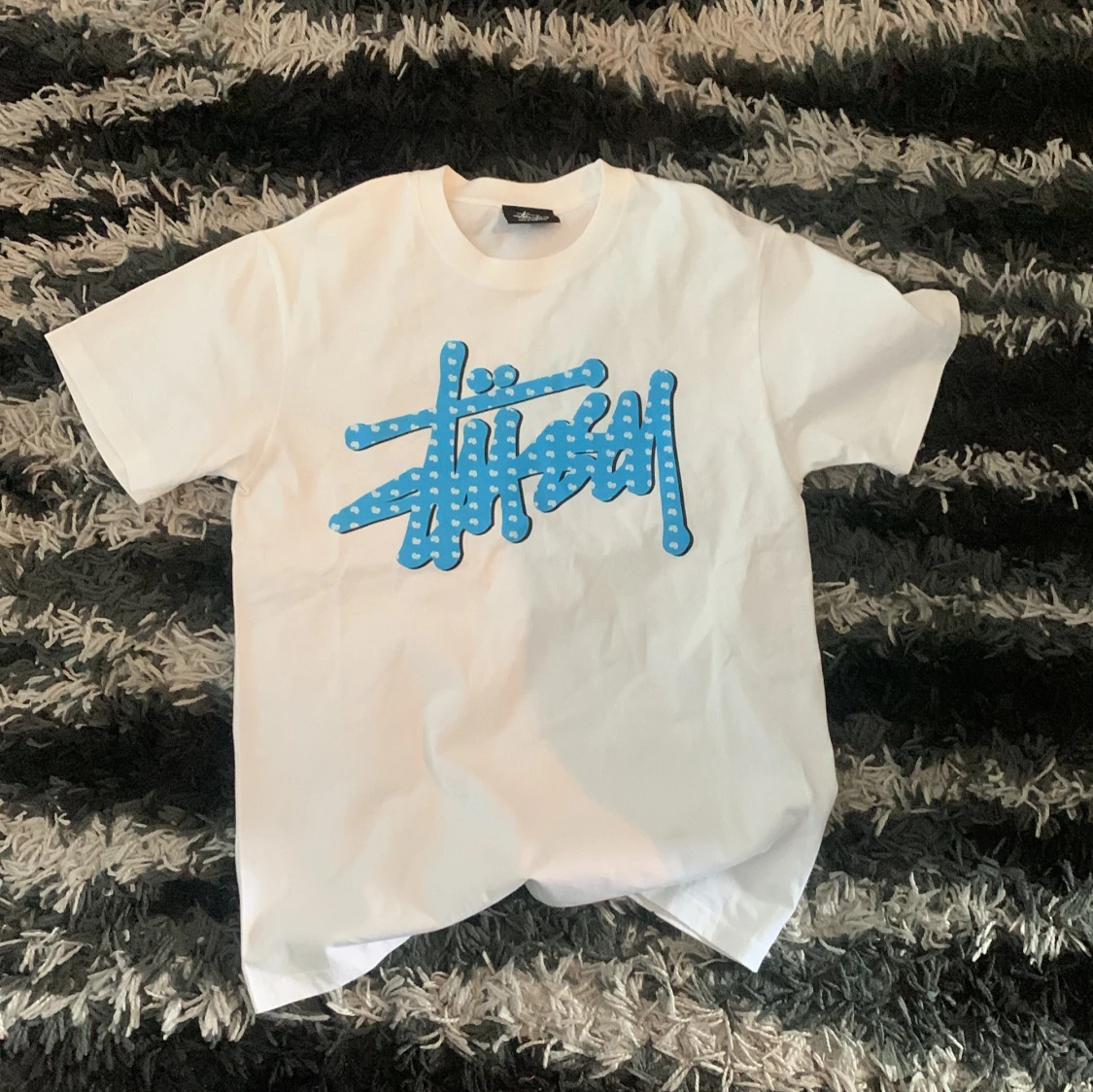 Vit t-shirt med blå Stüssy-logga