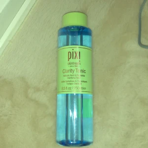 Pixi Clarity Tonic - Pixi Clarity Tonic är ett ansiktsvatten med salicylsyra och probiotika. Kommer i en genomskinlig blå plastflaska med grön kork och etikett. Innehåller 250 ml och passar för dig som vill ha en fräsch och klar hud. Oöppnad 